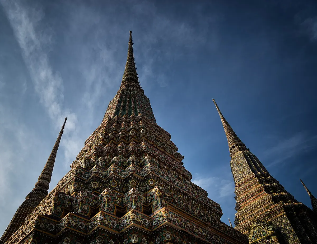 A tile-decorated great chedi of Wat Pho against a blue sky.