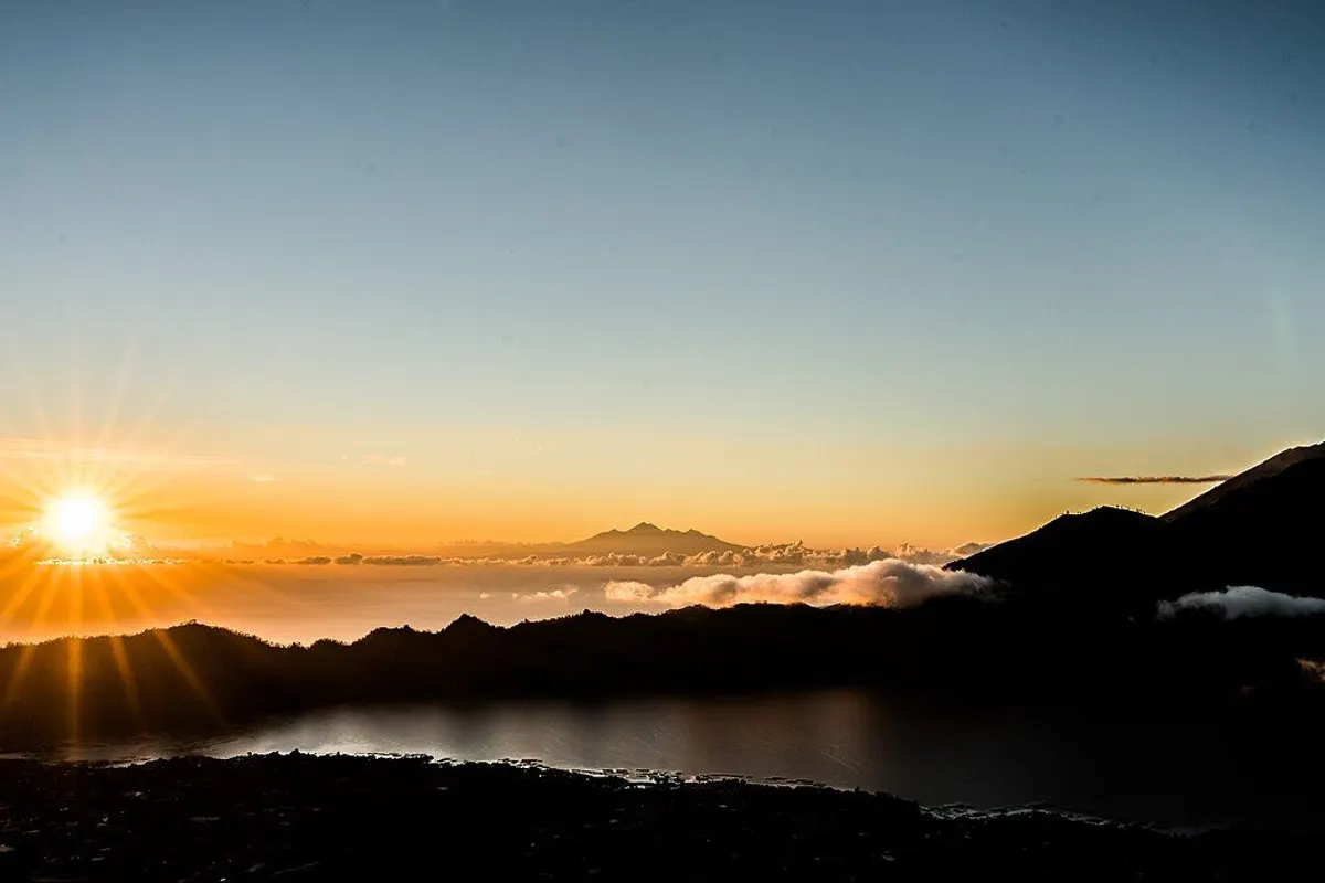 バトゥール山から見た日の出と眼下のバトゥール湖、雲の上にそびえる遠くの山。
