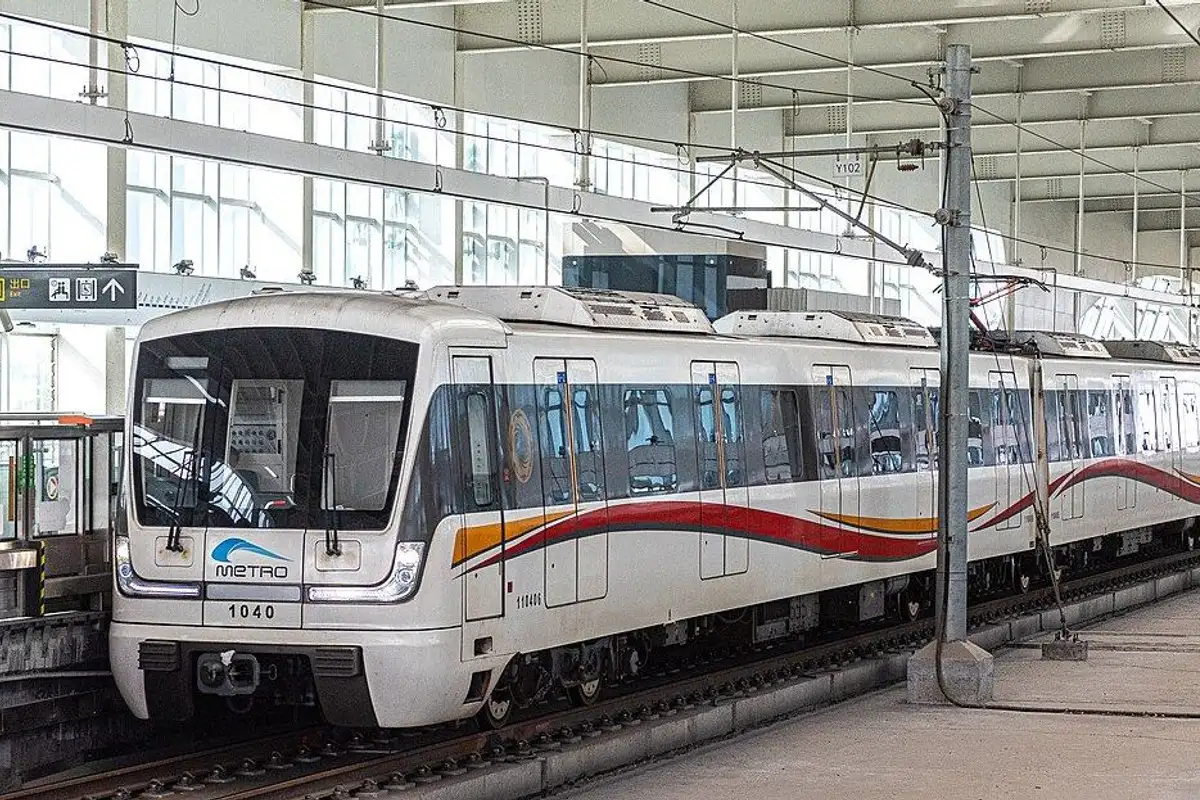 屋根のある高架駅に入ってくる、赤いラインが入った白い10号線の列車。