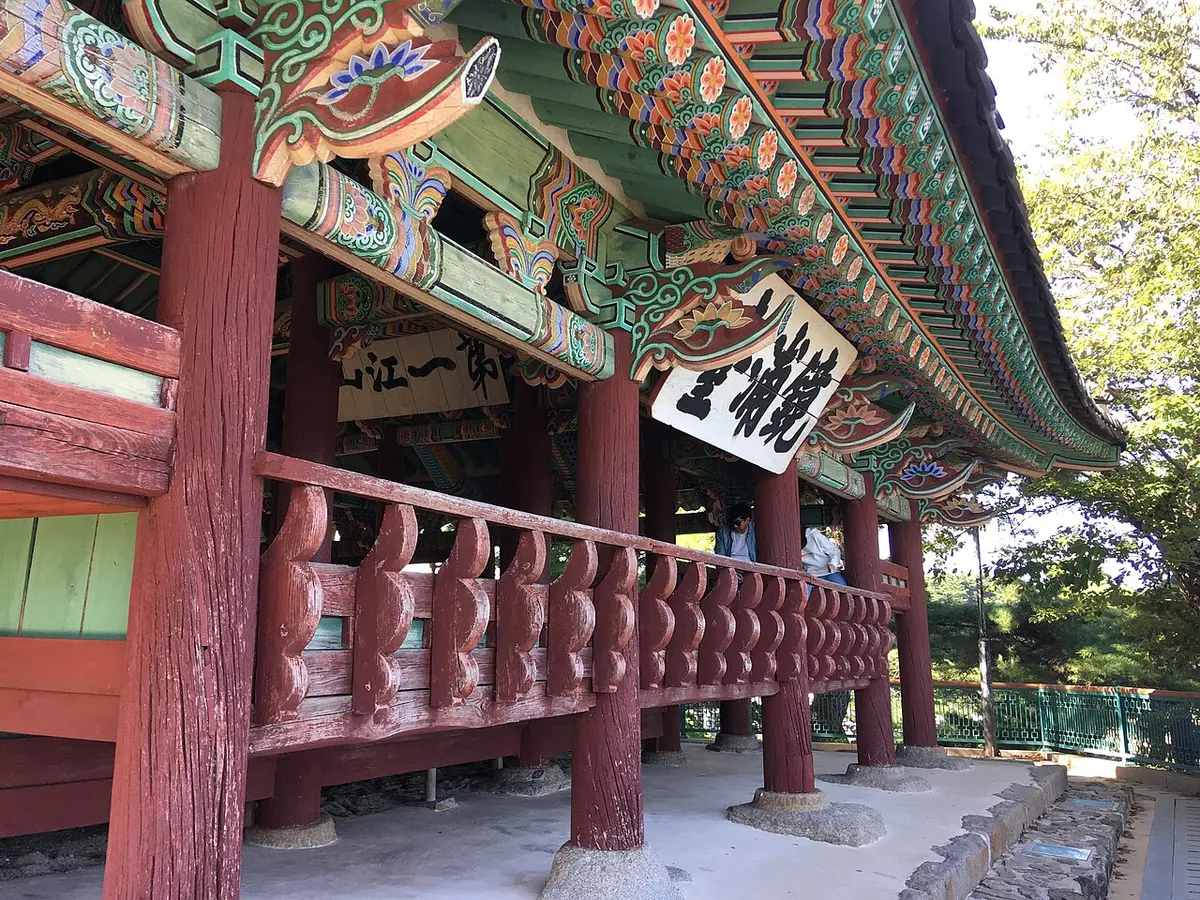 나무 사이 언덕 위에 선 팔작지붕 목조 누각 경포대.