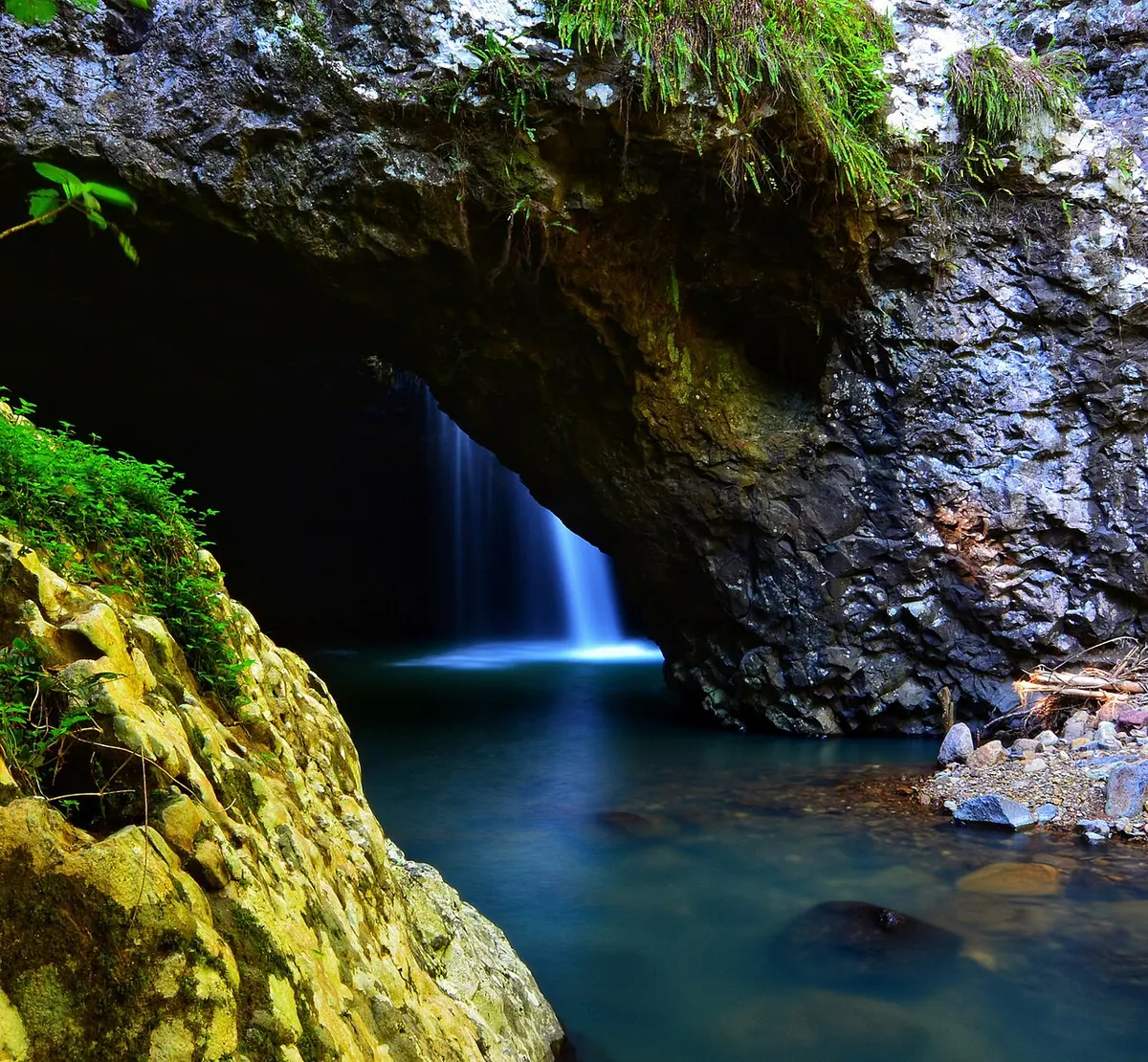 The rock arch of Natural Bridge in Springbrook National Park with water falling through it