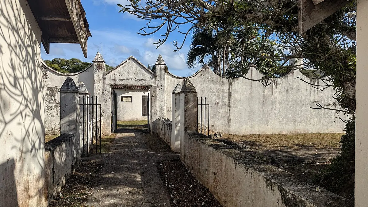 Old stone structures and lawns of Plaza de España in Hagåtña