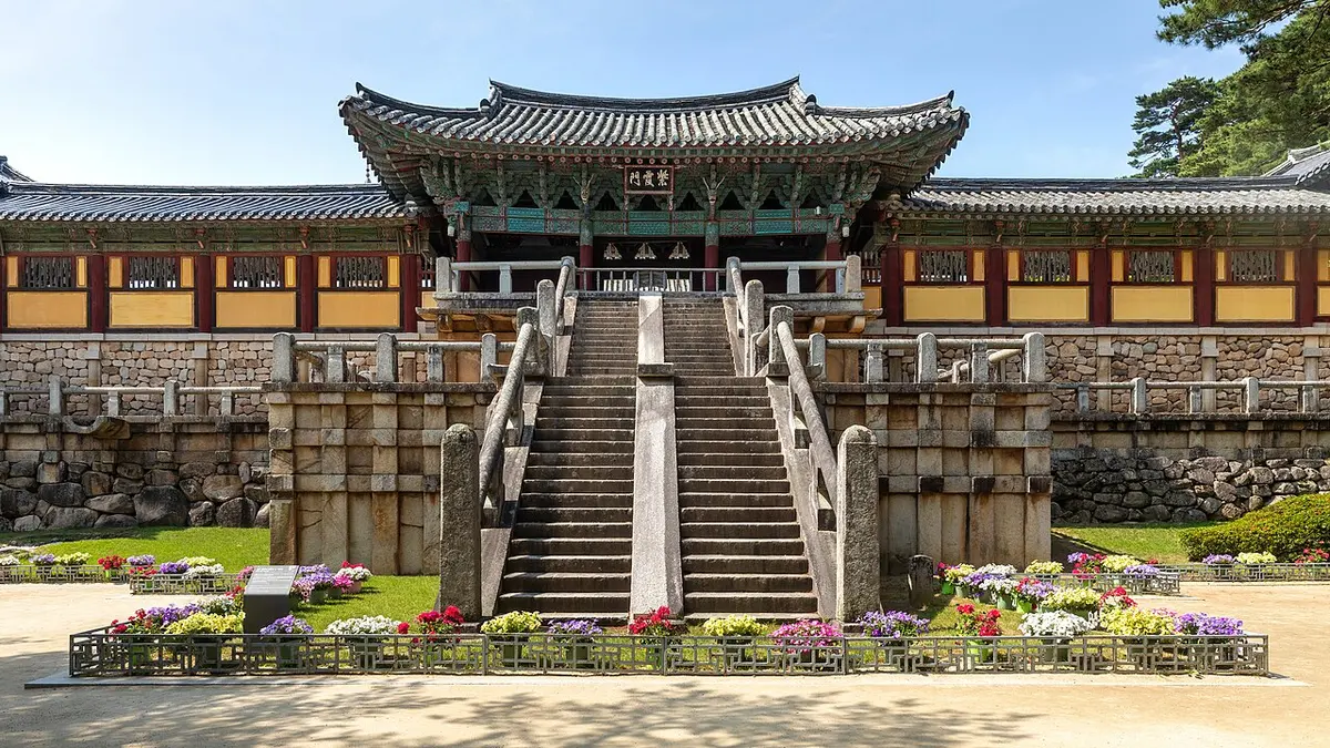 青空の下、花壇の向こうに見える仏国寺の青雲橋・白雲橋の石段と堂宇。