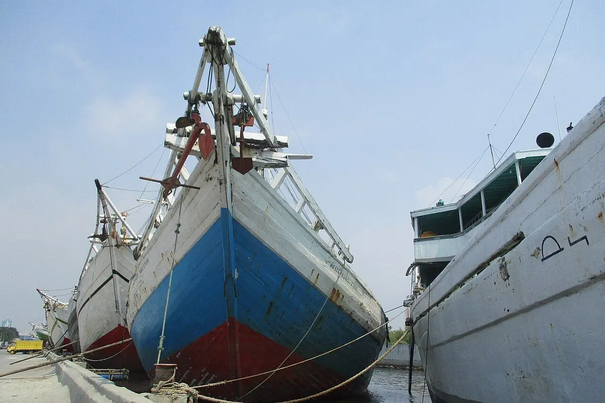 Wooden pinisi schooners moored in a row along the quay at Sunda Kelapa.