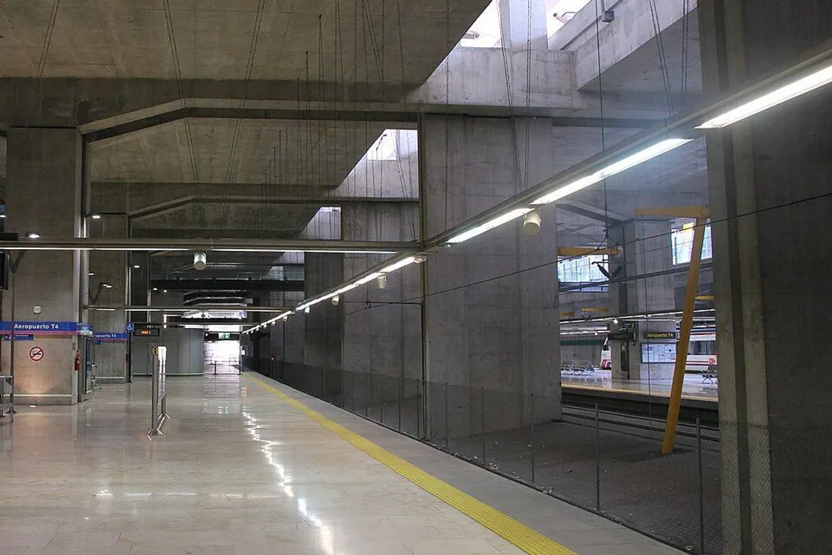 노출 콘크리트 기둥과 천창이 있는 공항 T4역 승강장.