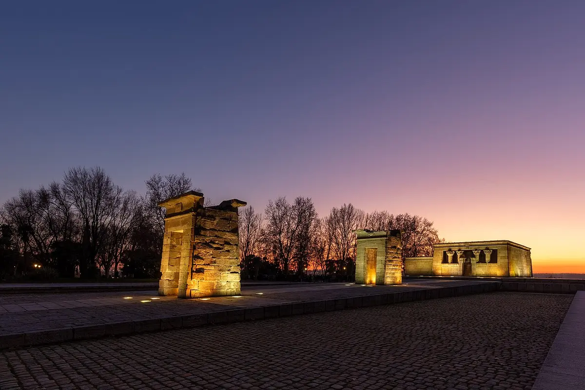 The Temple of Debod lit at dusk, with its pool in front