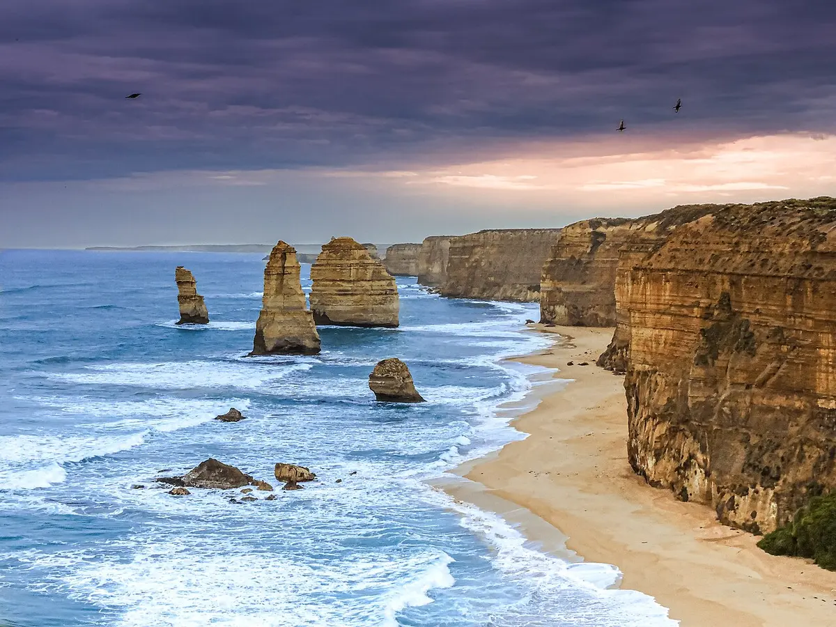 The Twelve Apostles rock stacks rising from the sea on a cloudy day