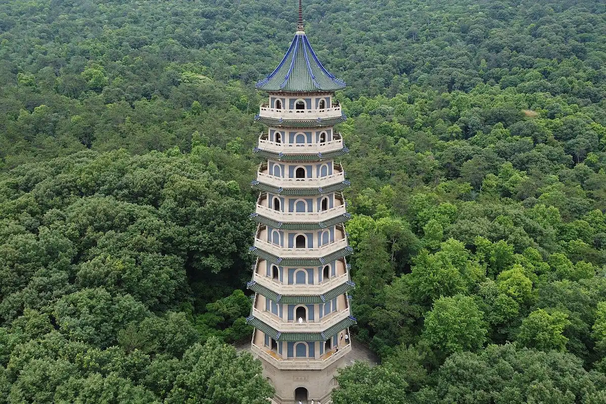 An aerial view of Linggu Pagoda rising from the middle of a green forest.