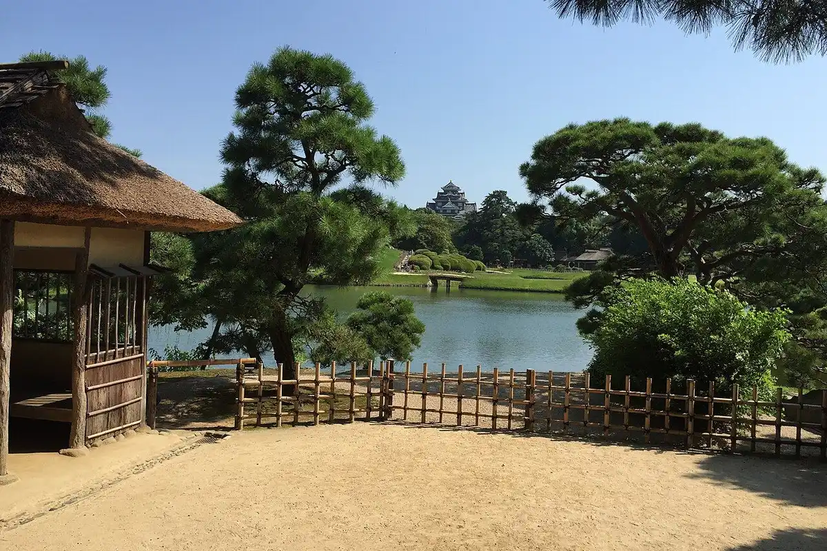 Lawns and trees of Okayama Korakuen garden with Okayama Castle in the background.