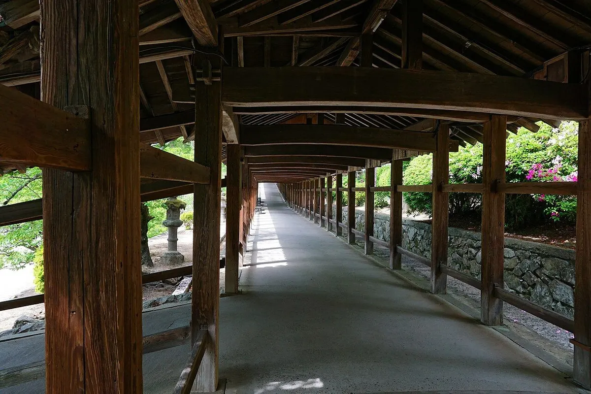 The long roofed wooden corridor of Kibitsu Shrine running straight ahead.