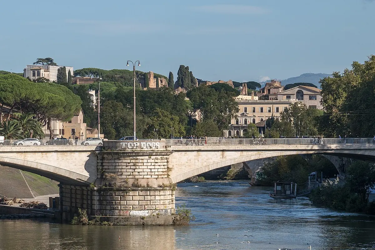 The Tiber flowing between tree-lined embankments, crossed by Ponte Garibaldi