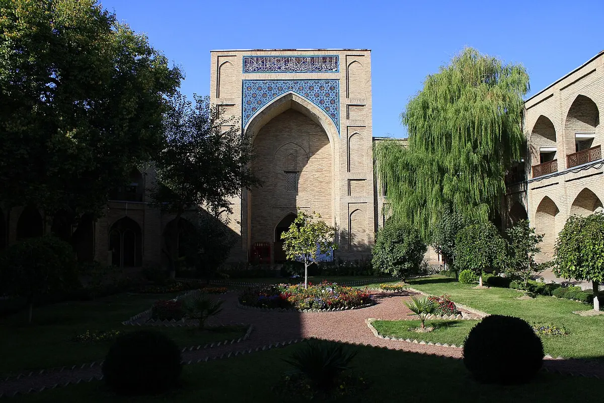 The courtyard of Kukeldash Madrasah in Tashkent, with its blue-tiled portal rising beyond the garden.