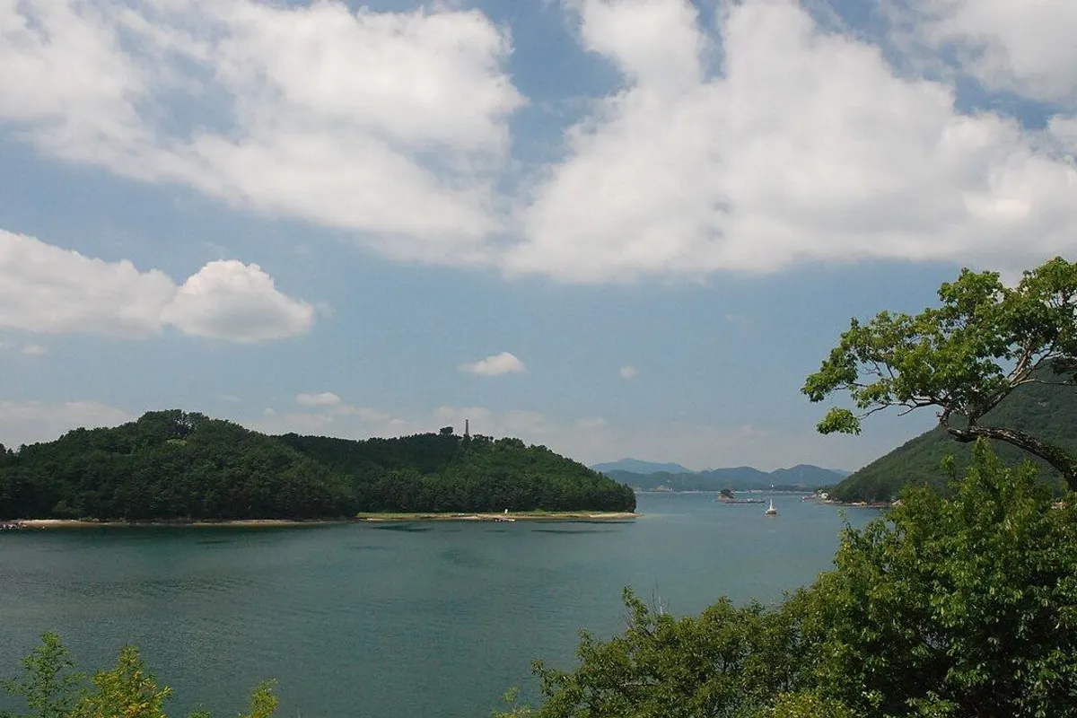 夏雲の下に広がる閑山島の森の岬と穏やかな入り江。