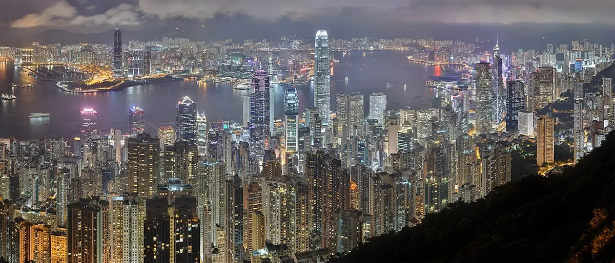 The illuminated Hong Kong Island and Kowloon skyline at night, seen from Lugard Road on Victoria Peak.