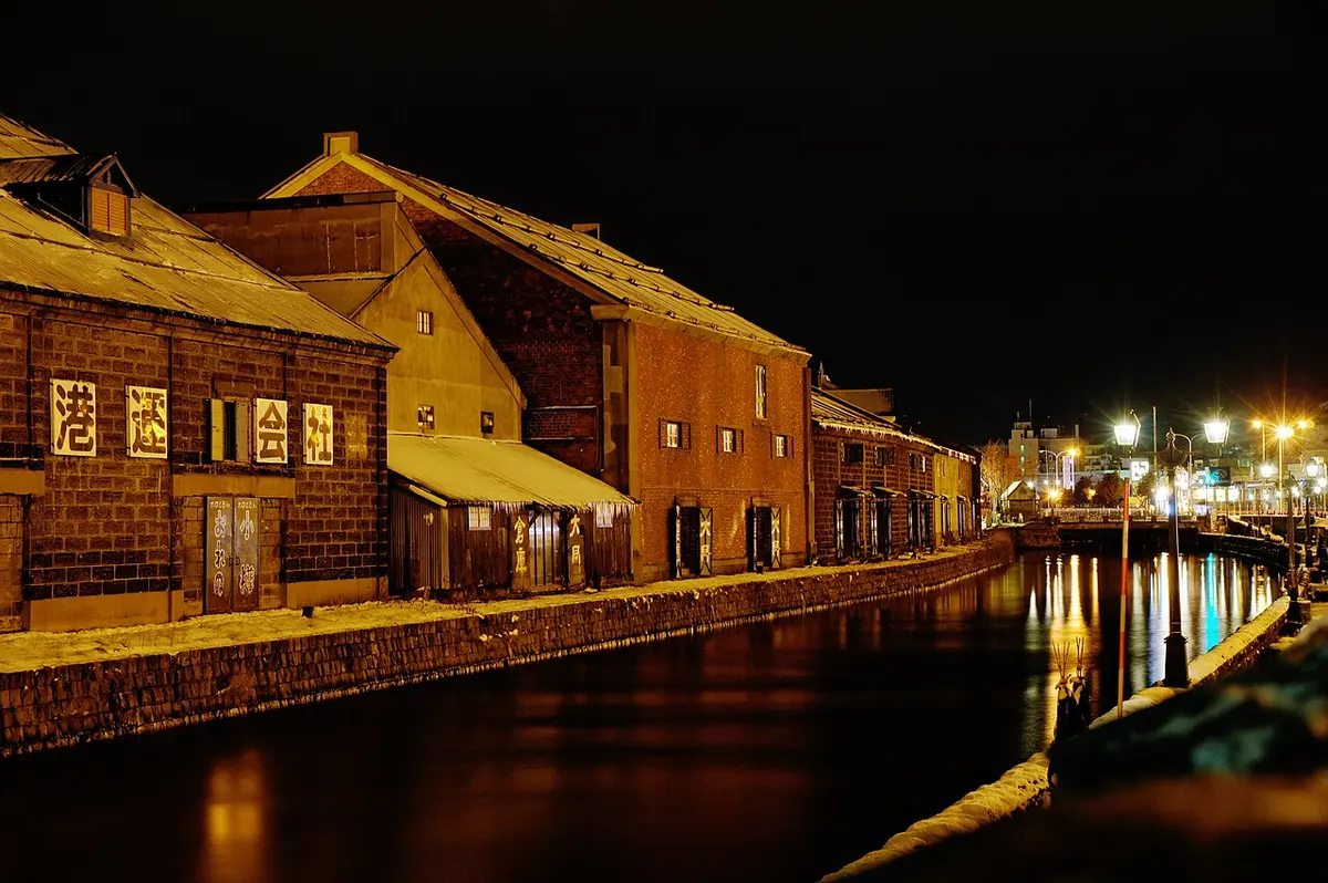 Otaru Canal at night with its lamps lit beside old stone warehouses.