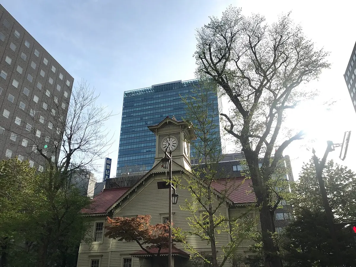 The white wooden Sapporo Clock Tower with its clock on top.