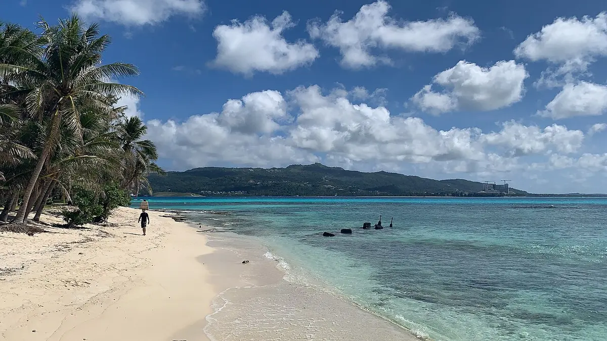 Palm-lined beach and clear water on Managaha Island, Saipan